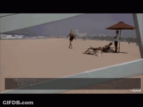 A Woman Walking On A Beach With Hollywood Girls 3 Written On The Bottom GIF