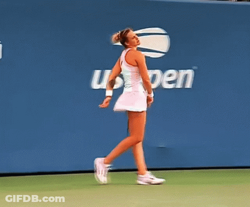 A Woman Walking On A Tennis Court In Front Of A Wall That Says Open GIF