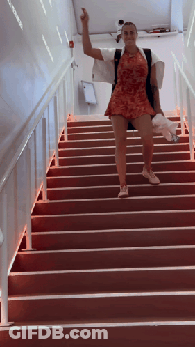 A Woman Walking Up A Set Of Red Stairs GIF