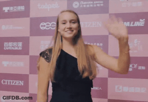 A Woman Waving In Front Of A Wall That Has Citizen On It GIF
