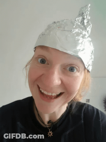 A Woman Wearing A Aluminum Foil Hat Smiles For The Camera GIF