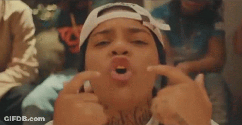 A Woman Wearing A Bandana And A Hat Is Making A Funny Face With Her Hands . GIF