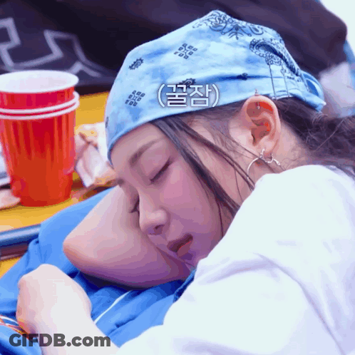 A Woman Wearing A Bandana Is Sleeping On A Man 'S Shoulder GIF