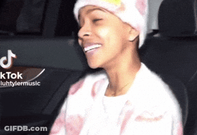A Woman Wearing A Beanie Is Smiling In A Car With A Tiktok Logo In The Background GIF