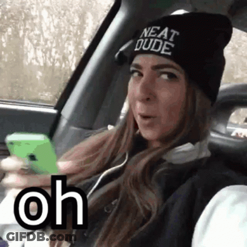 A Woman Wearing A Beanie That Says Neat Dude Is Sitting In A Car GIF