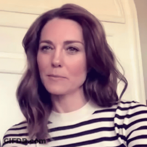A Woman Wearing A Black And White Striped Shirt Is Looking At The Camera . GIF