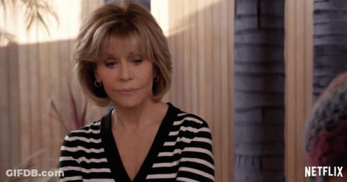 A Woman Wearing A Black And White Striped Shirt With A Netflix Logo On The Bottom GIF