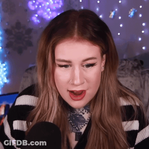 A Woman Wearing A Black And White Striped Sweater Has A Nose Ring GIF