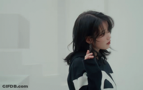 A Woman Wearing A Black And White Striped Sweatshirt Holds Her Hand To Her Face GIF