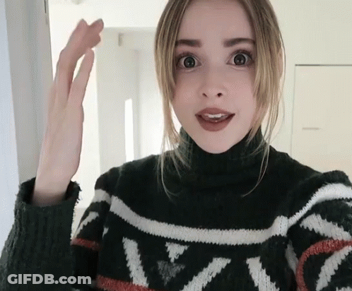 A Woman Wearing A Black And White Sweater With The Letter N On It GIF