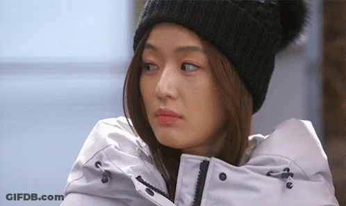 A Woman Wearing A Black Beanie And A White Jacket GIF