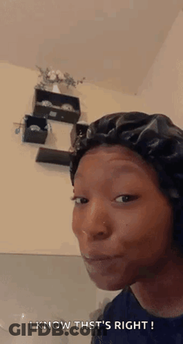 A Woman Wearing A Black Bonnet Is Making A Funny Face . GIF