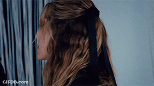 A Woman Wearing A Black Bow In Her Hair GIF