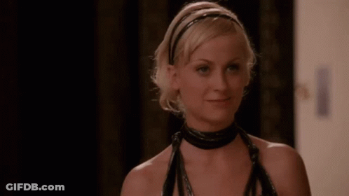 A Woman Wearing A Black Choker And A Headband Is Smiling And Looking At The Camera . GIF