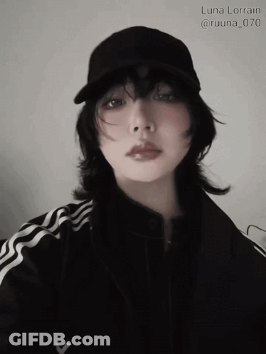 A Woman Wearing A Black Hat And A Black Jacket Has The Name Luna Lorain Written Above Her GIF