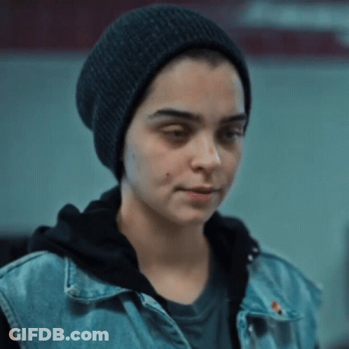 A Woman Wearing A Black Hat And A Denim Vest GIF