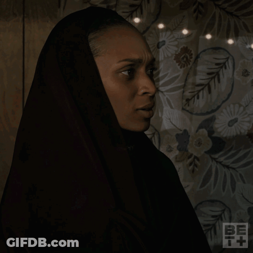 A Woman Wearing A Black Head Scarf Is Asking What Are You Talking About GIF
