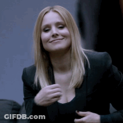 A Woman Wearing A Black Jacket And A Black Top Is Smiling GIF