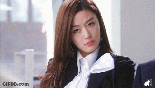 A Woman Wearing A Black Jacket And A White Shirt With A Bow GIF