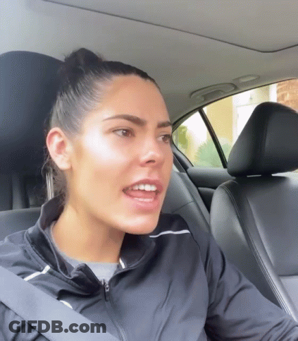 A Woman Wearing A Black Jacket Is Sitting In A Car GIF