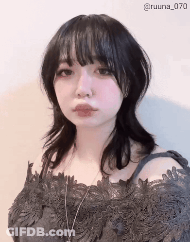 A Woman Wearing A Black Lace Off The Shoulder Top And A Necklace With The Number 070 On The Bottom GIF