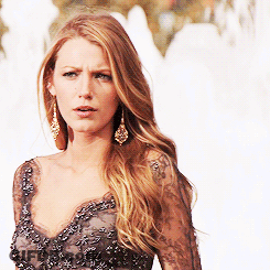 A Woman Wearing A Black Lace Top And Earrings GIF