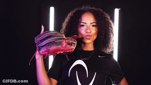A Woman Wearing A Black Nike Shirt Is Holding A Red Baseball Glove GIF