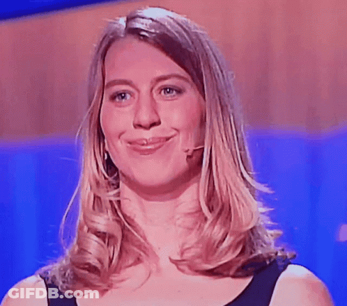 A Woman Wearing A Black Shirt And A Microphone Smiles For The Camera GIF