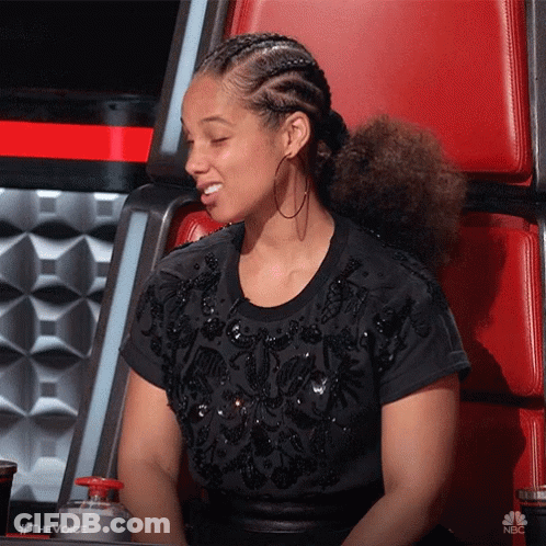 A Woman Wearing A Black Shirt And Hoop Earrings Is Sitting In A Chair With Her Eyes Closed .. GIF