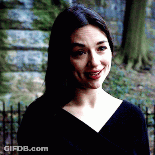A Woman Wearing A Black Shirt And Red Lipstick Is Smiling GIF