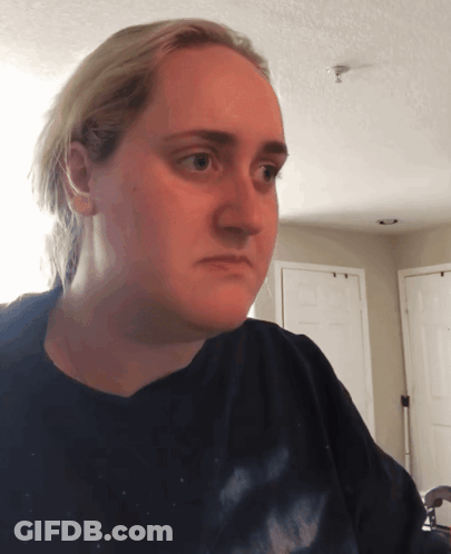 A Woman Wearing A Black Shirt Is Looking At The Camera GIF