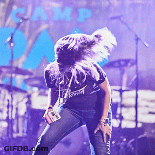 A Woman Wearing A Black Shirt That Says Stomn Is Dancing On Stage GIF