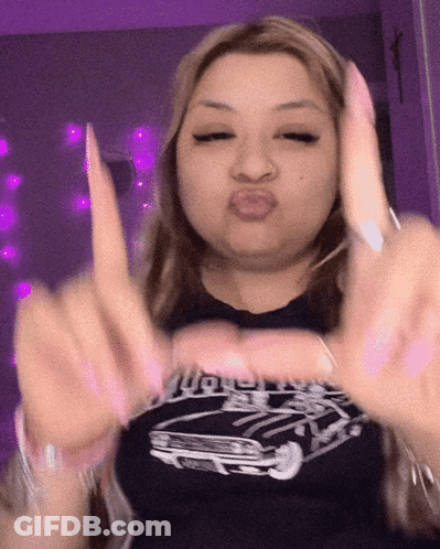 A Woman Wearing A Black Shirt With A Car On It Making A Funny Face GIF