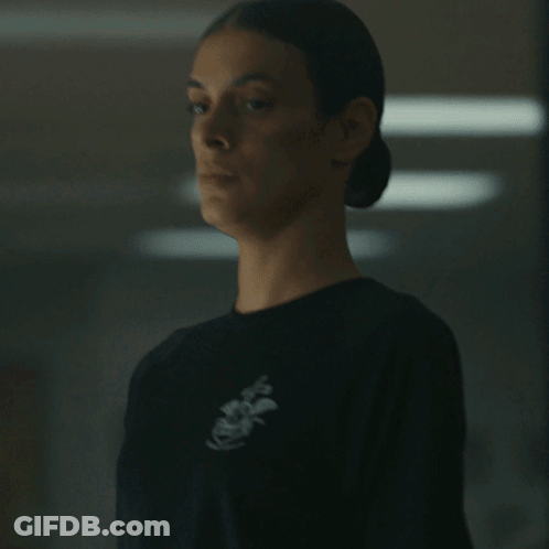 A Woman Wearing A Black Shirt With An Anchor On The Front GIF