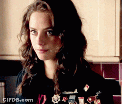 A Woman Wearing A Black Shirt With The Number 12 On It Is Standing In A Kitchen GIF