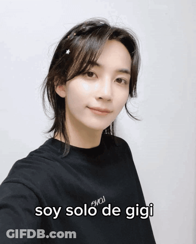 A Woman Wearing A Black Shirt With The Words Soy Solo De Gigi On The Front GIF