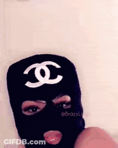 A Woman Wearing A Black Ski Mask With A White Chanel Logo On It . GIF
