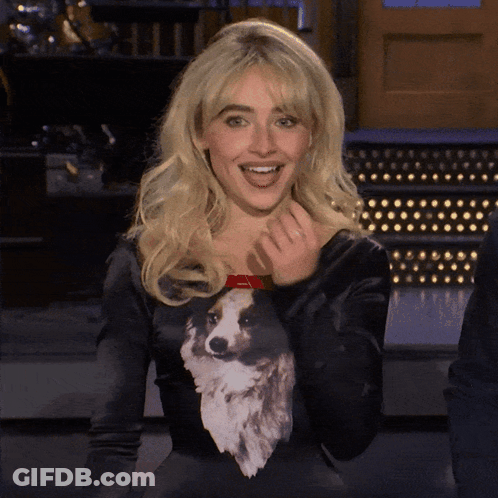 A Woman Wearing A Black Sweater With A Dog On It GIF