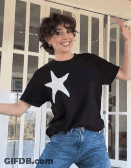 A Woman Wearing A Black T-Shirt With A White Star On It Is Dancing GIF