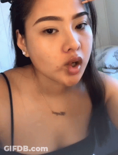 A Woman Wearing A Black Top And A Necklace That Says ' L' Amour ' On It GIF
