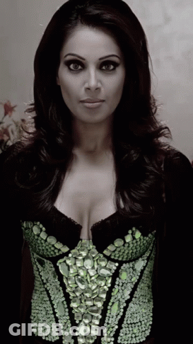A Woman Wearing A Black Top With Green Rhinestones GIF
