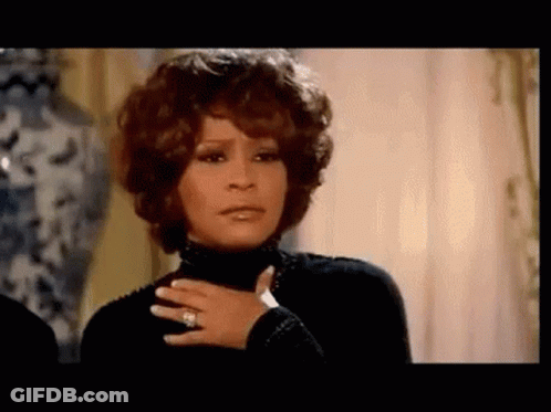 A Woman Wearing A Black Turtleneck And A Ring On Her Finger . GIF