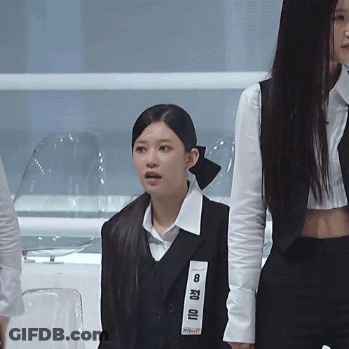 A Woman Wearing A Black Vest With The Number 8 On The Front GIF