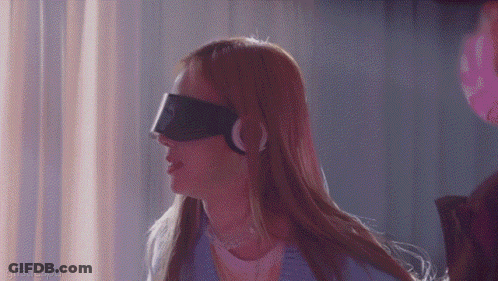 A Woman Wearing A Blindfold And Headphones Is Standing In A Dark Room . GIF
