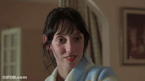 A Woman Wearing A Blue And White Striped Robe Smiles At The Camera GIF