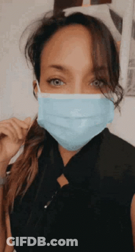 A Woman Wearing A Blue Face Mask With A Ponytail . GIF