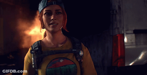 A Woman Wearing A Blue Hat And A Yellow Shirt With A Mountain On It Is Smiling GIF