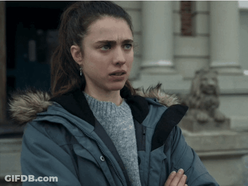 A Woman Wearing A Blue Jacket With A Fur Hood Is Standing In Front Of A Building GIF