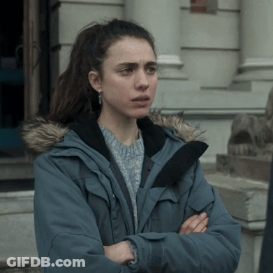 A Woman Wearing A Blue Jacket With A Fur Hood Stands With Her Arms Crossed GIF