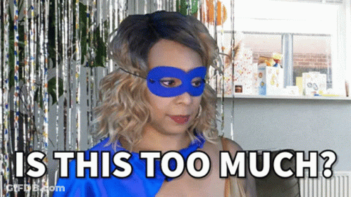 A Woman Wearing A Blue Mask With The Words Is This Too Much Behind Her GIF
